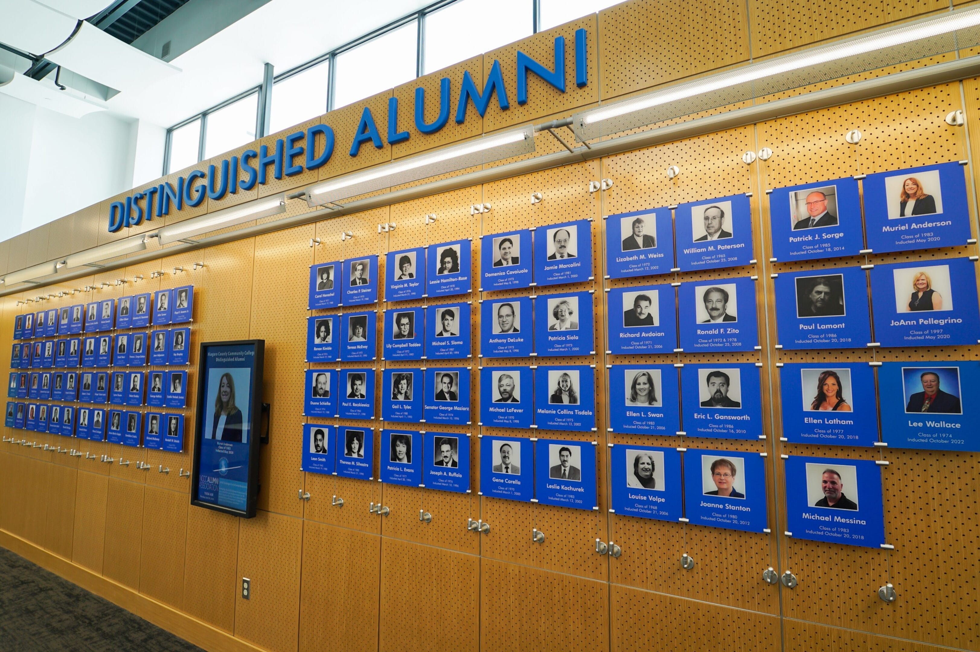A wall filled with photos honoring distinguished alumni from SUNY Niagara